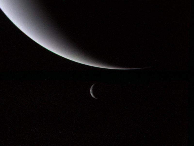 A photo of Neptune and its moon, Triton, taken by Voyager 2. Triton's orbit will eventually take it within Neptune's Roche limit, tearing it apart and potentially forming a new ring system. (<a href="http://en.wikipedia.org/wiki/File:Voyager_2_Neptune_and_Triton.jpg" target="_blank" rel="noopener">NASA</a>)