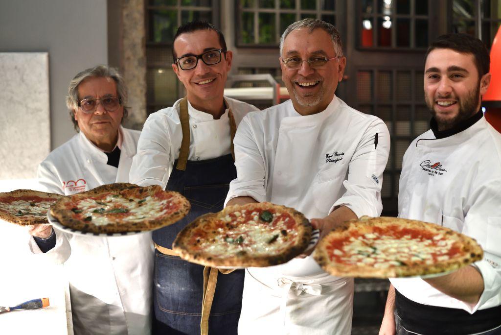 (L–R) Neapolitan pizza-makers Antonio Starita, Gino Sorbillo, Enzo Coccia, and Ciro Oliva pose with pizzas in Naples, Italy, on Dec. 6, 2017. UNESCO said on Dec. 7, 2017, that the art of the Neapolitan "Pizzaiuolo" (pizza-maker) has been put on its prestigious Intangible Cultural Heritage list. (Tiziana Fabi/AFP via Getty Images)