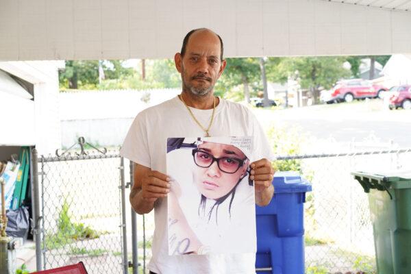 Domingo Ramos holds a picture of Shaniece Harris in front of his garage in Middletown, N.Y., on Aug. 25, 2022. (Cara Ding/The Epoch Times)