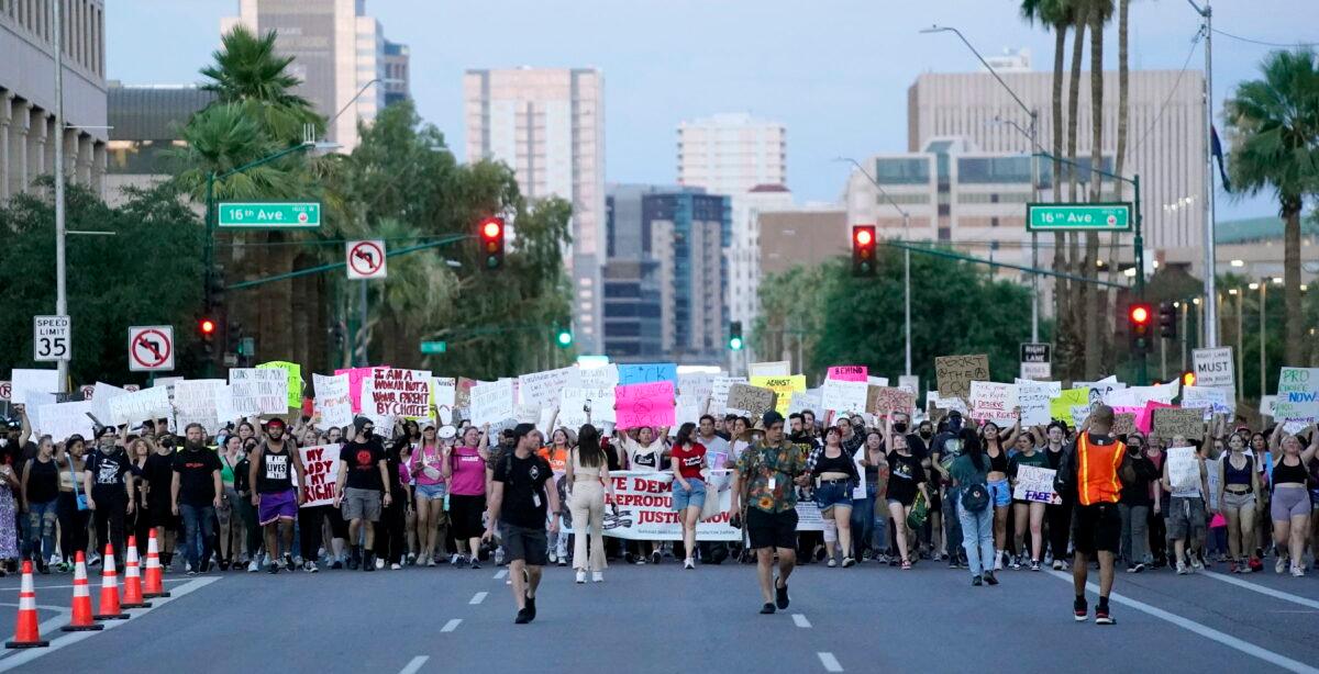 Thousands of protesters march around the Arizona Capitol after the Supreme Court decision to overturn the landmark Roe v. Wade abortion decision, on June 24, 2022, in Phoenix. (AP Photo/Ross D. Franklin)