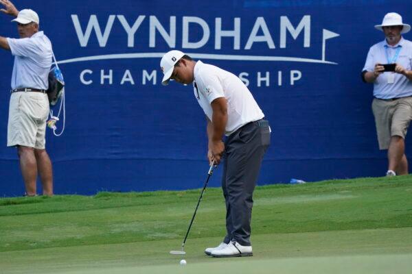 Joohyoung Kim, right, of South Korea, putts on the 18th hole during the final round of the Wyndham Championship golf tournament in Greensboro, N.C., Sunday, Aug. 7, 2022. (Chuck Burton/AP Photo)