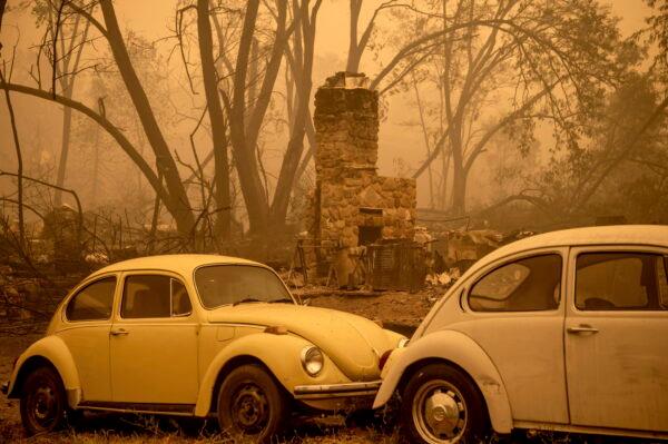 A chimney stands behind cars as the McKinney Fire burns in Klamath National Forest, Calif., on July 31, 2022. (Noah Berger/AP Photo)