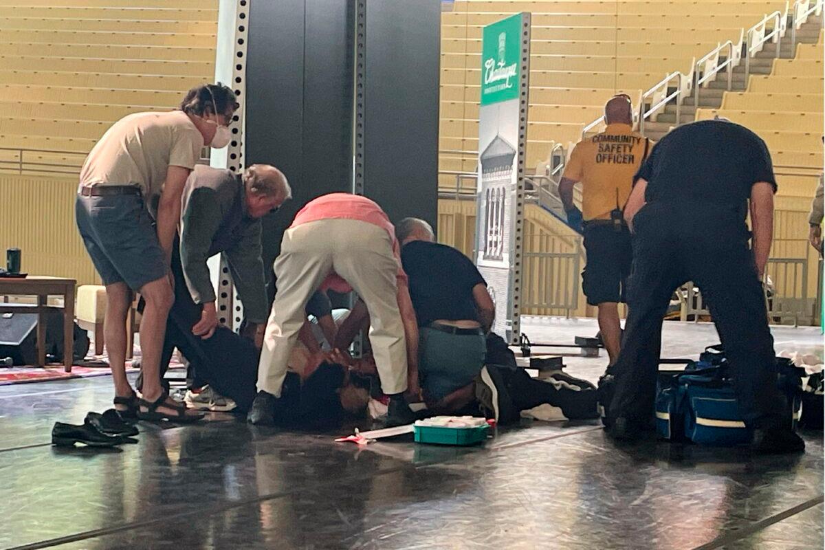 Author Salman Rushdie is tended to after he was attacked during a lecture at the Chautauqua Institution in Chautauqua, N.Y., on Aug. 12, 2022. (Joshua Goodman/AP Photo)