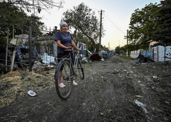 A woman stands near buildings destroyed by a military strike, in Chaplyne, Dnipropetrovsk region, Ukraine, on Aug. 24, 2022. (Dmytro Smolienko/Reuters)