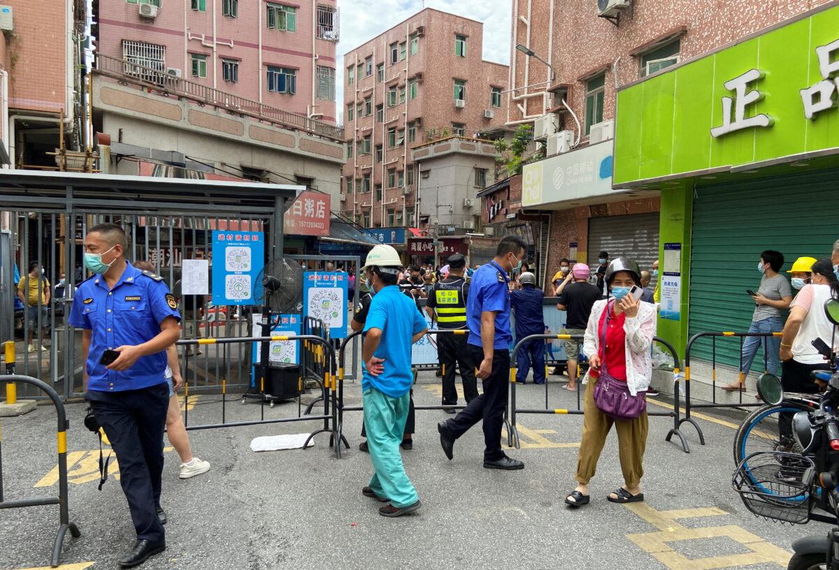 Security guards stand at an entrance to Wanxia urban village, which has been closed as part of COVID-19 measures in Shenzhen, Guangdong Province, China, on Aug. 29, 2022. (David Kirton/Reuters)