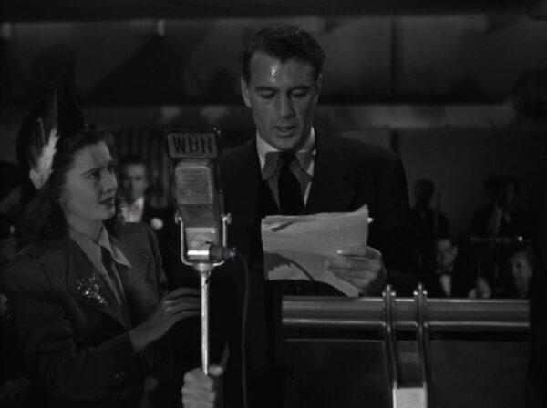 Barbara Stanwyck as Ann Mitchel stands near Gary Cooper as John Doe reads a speech and changes to a confident spokesman for common people in "Meet John Doe." (Warner Bros.)