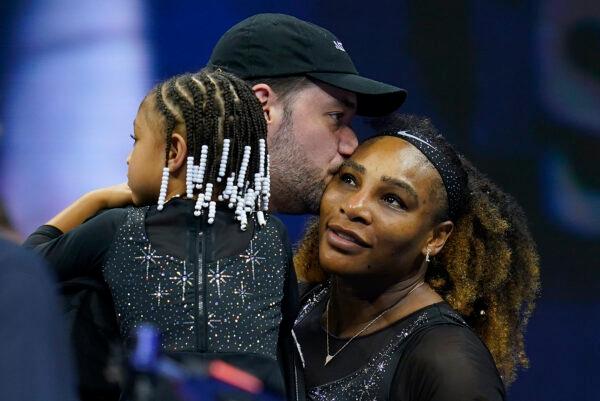 Serena Williams gets a kiss from her husband Alexis Ohanian as their daughter Olympia looks on, after Williams defeated Danka Kovinic, of Montenegro, during the first round of the US Open tennis championships in New York, on Aug. 29, 2022. (AP Photo/Charles Krupa)