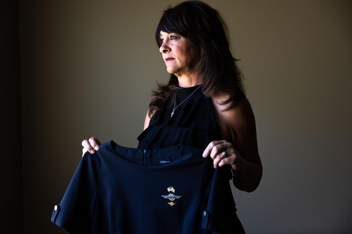 Charlene Carter, who worked for Southwest Airlines as a flight attendant for 21 years before she was fired, holds her former Southwest flight attendant's uniform at her home in Aurora, Colo., on Aug. 30, 2022. (Michael Ciaglo for The Epoch Times)