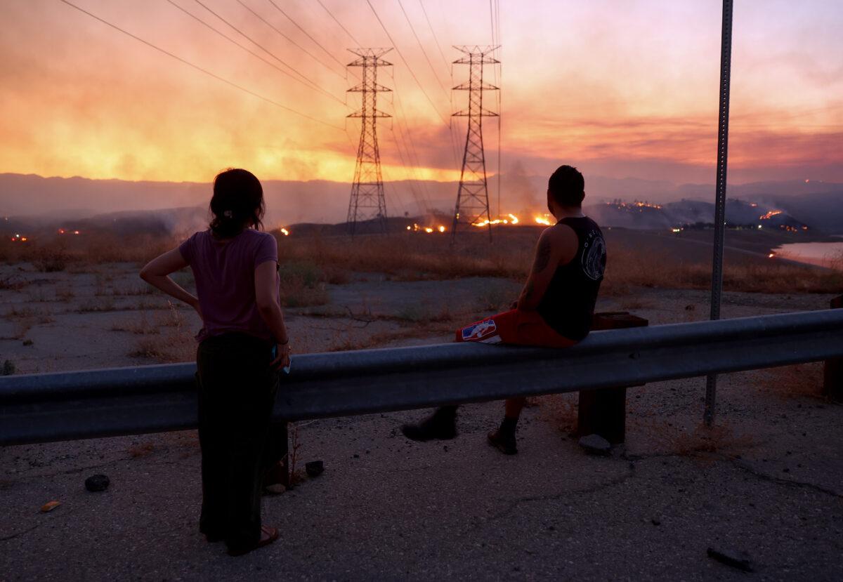 Residents who were evacuated from their home watch as the Route Fire burns near Castaic, California, on Aug. 31, 2022. (Mario Tama/Getty Images)