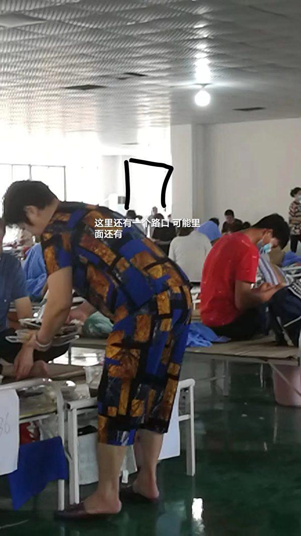 Inside a makeshift hospital in Guixi City, Jiangxi Province. The Chinese characters indicate that there are more beds in the direction of the black arrow. (Courtesy of interviewee)