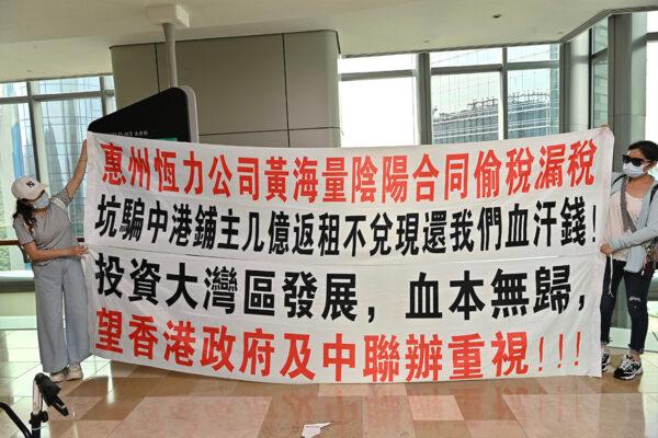 About thirty people assembled at the Securities and Futures Commission, asking the authorities to conduct a thorough investigation into the alleged property purchase scams in the Greater Bay Area of China on Aug. 30, 2022. The notice explains the investors' predicament. (Sung Pi-Lung/The Epoch Times)