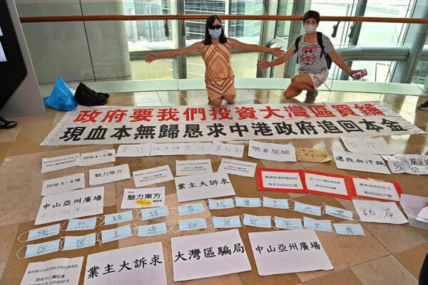 About thirty people assembled at the Securities and Futures Commission, asking the authorities to conduct a thorough investigation into the alleged property purchase scams in the Greater Bay Area of China on Aug. 30, 2022. The notices set out their situation and their demands for help to recover their losses.  (Sung Pi-Lung/The Epoch Times)