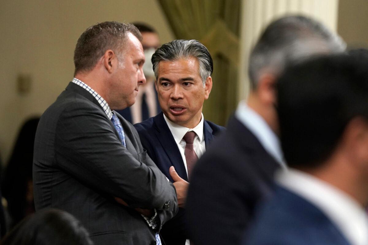 California Attorney General Rob Bonta (R) talks with Assemblyman Adam Gray, (D-Merced), as lawmakers discussed a gun control measure in the Assembly in Sacramento, Calif., on Sept. 1, 2022.(Rich Pedroncelli/AP Photo)
