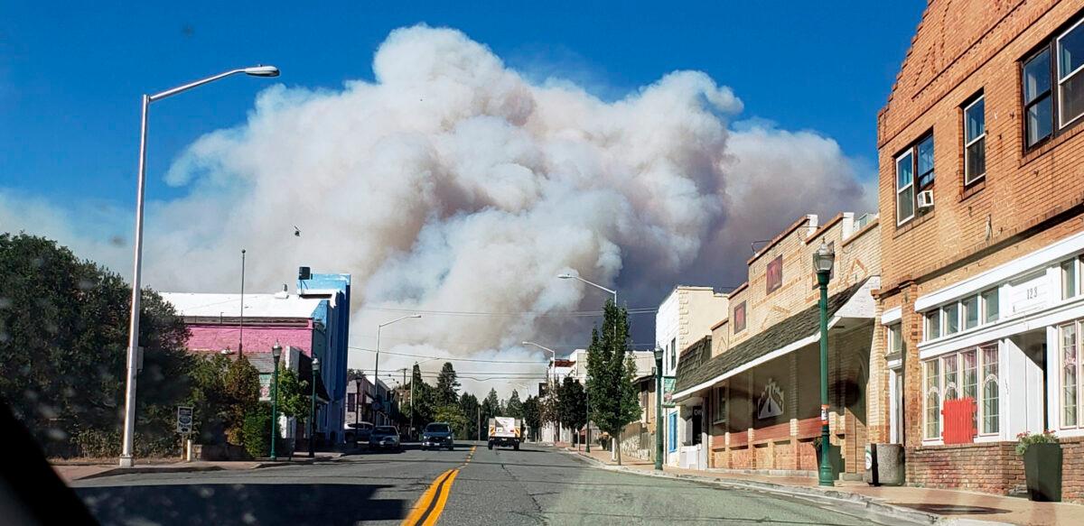 A plum of smoke covers the sky as the the Mill Fire approaches in Weed, Calif., on Sept. 2, 2022. (Hung T. Vu/The Record Searchlight via AP)