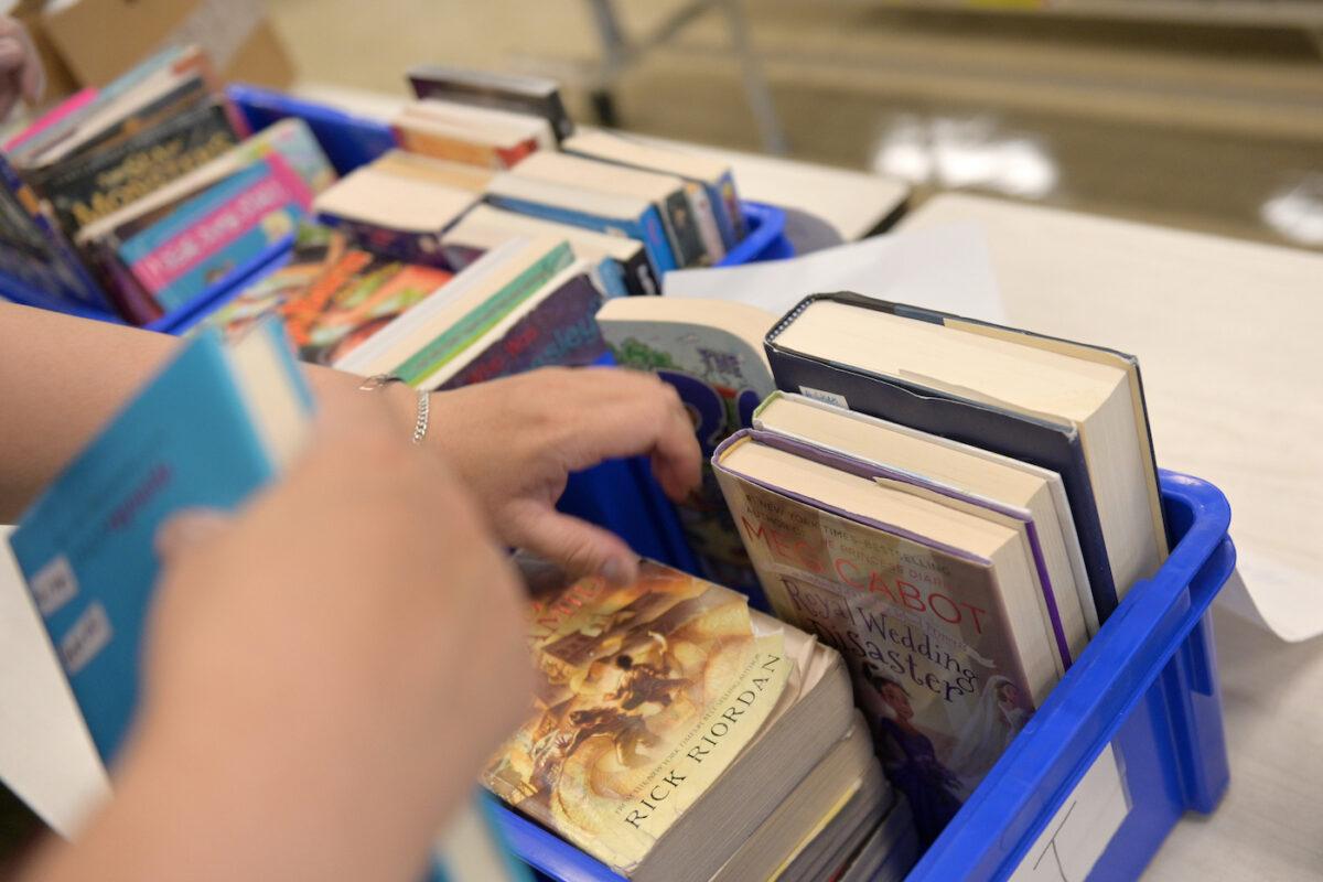 A schoolteacher sorts through library books collected from students at a New York City school on June 29, 2020. (Michael Loccisano/Getty Images)