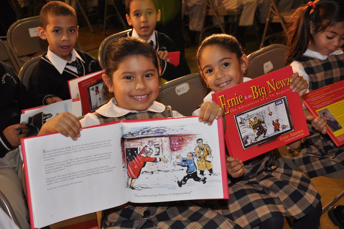 Elementary schoolchildren with Ernie Anastos’ book, "Ernie & the Big Newz," at Christ the King School in the Bronx, New York. (Courtesy of St. Francis Food Pantries and Shelters)