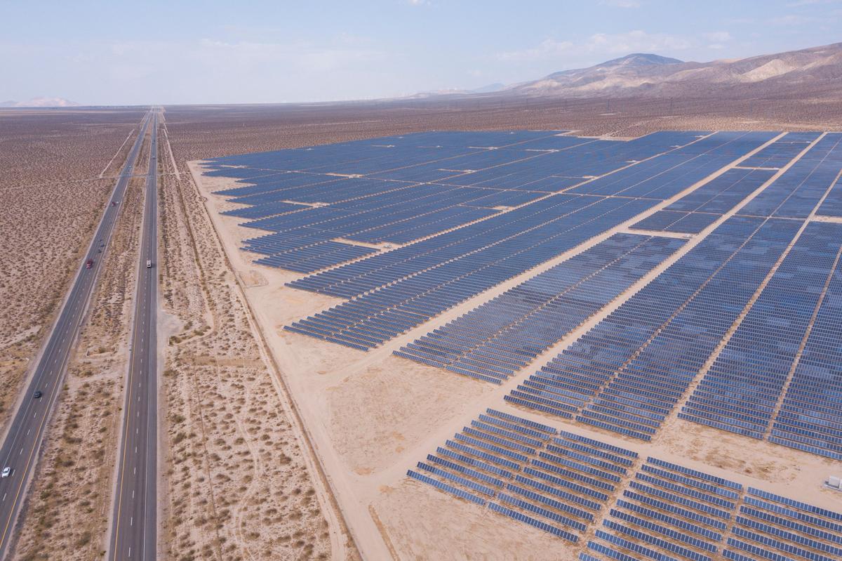 An aerial image shows vehicles driving on the California 14 Highway as solar panels, part of an electricity generation plant in Kern County near Mojave, Calif., on June 18, 2021. (Patrick T. Fallon/AFP via Getty Images)