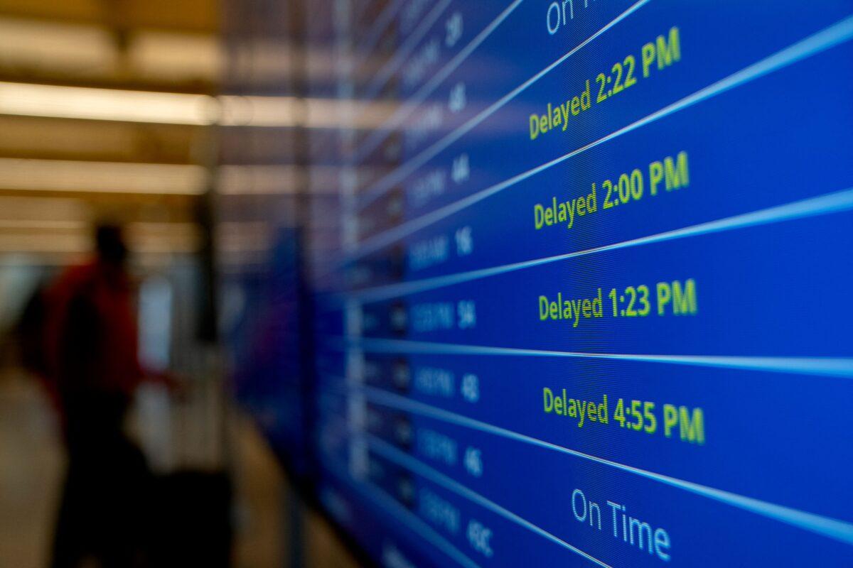 Delayed signs are displayed on the flight schedule board at Ronald Reagan Washington National Airport in Arlington, Virginia, on January 18, 2022. (Stefani Reynolds / AFP via Getty Images)