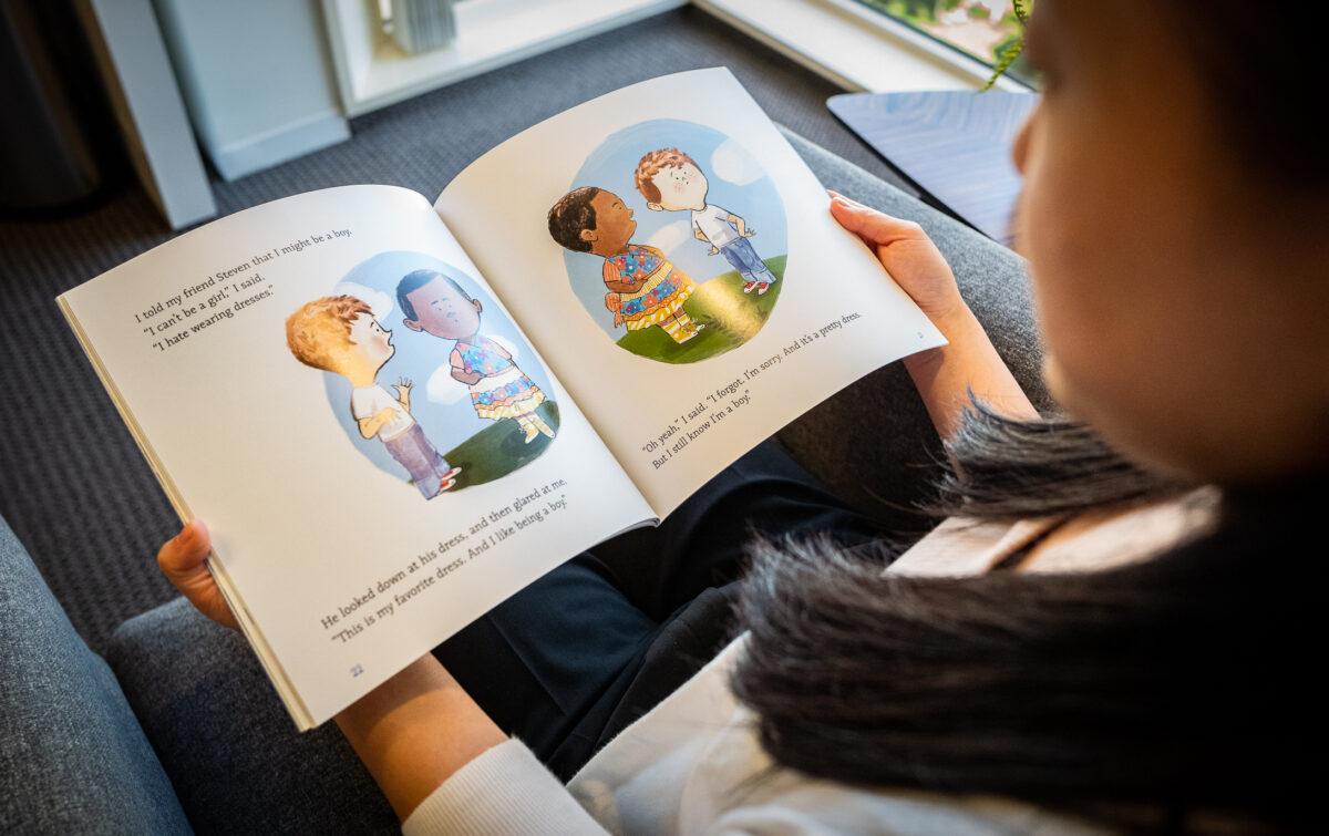 A woman reads a transgender children's book in Irvine, Calif., on Aug. 30, 2022. (John Fredricks/The Epoch Times)