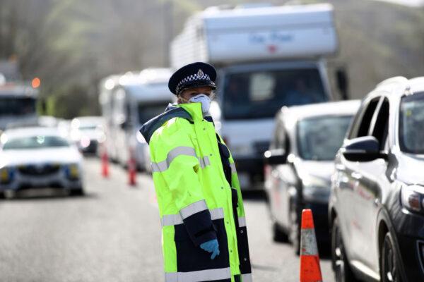 Police stop vehicles at a checkpoint on SH1 north of Wellsford in Auckland, New Zealand, on Aug. 12, 2020. Auckland was placed in full COVID lockdown for three days, with all residents ordered to work from home unless they are essential workers and all schools and childcare centers to close.  (Fiona Goodall/Getty Images)