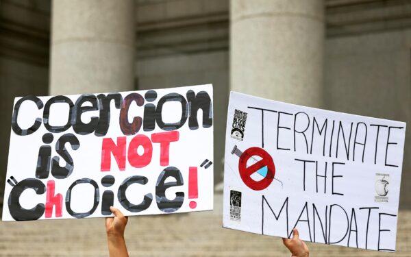 A person holds up a signs as people hold a rally in support of a group of teachers fighting enforcement of the coronavirus (COVID-19) vaccine mandate for public school employees at Thurgood Marshall United States Courthouse, in New York City, on Oct. 12, 2021. (Michael M. Santiago/Getty Images)