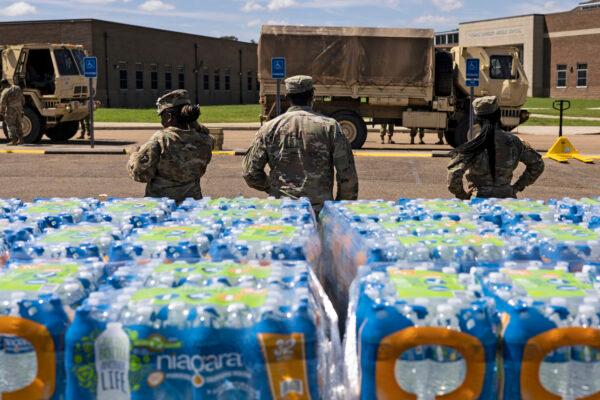 Members of the Mississippi National Guard hand out bottled water at Thomas Cardozo Middle School in response to the water crisis in Jackson, Miss., on Sept. 1, 2022. (Brad Vest/Getty Images)