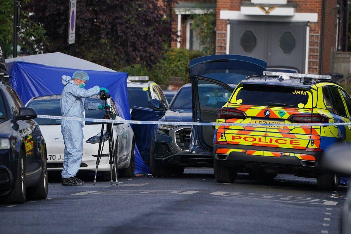 A forensics officer takes photographs of the scene where 24-year-old Chris Kaba was killed by police in Kirkstall Gardens, Streatham Hill, south London, on Sept. 5, 2022. (PA)