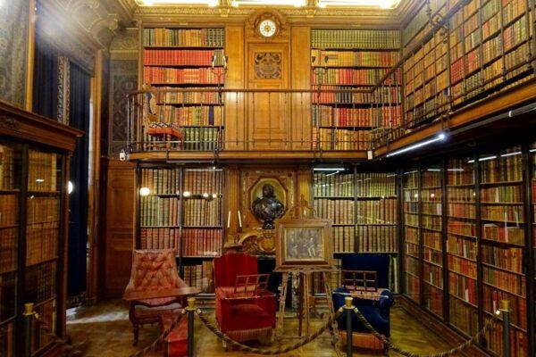 The reading room, located in the private suites, was designed by architect Honoré Daumet in the French-Renaissance style. The duke was one of the greatest bibliophiles of his time, and the Château de Chantilly has one of the most extensive libraries and collections of rare manuscripts in France. One of the most precious manuscripts contained is the “Très riches heures du duc de Berry” (“The Very Rich Hours of the Duke of Berry”), reputed to be one of the most beautiful manuscripts in the world. The room, with wood shelves on a two-level metal structure and a fireplace, is simple yet functional, and is typical of 19th-century library architecture. (<a href="https://commons.wikimedia.org/wiki/File:Chantilly_(60),_ch%C3%A2teau,_biblioth%C3%A8que_Cond%C3%A9,_extr%C3%A9mit%C3%A9_sud-ouest_3.jpg">Pierre Poschadel/CC BY-SA 4.0</a>)