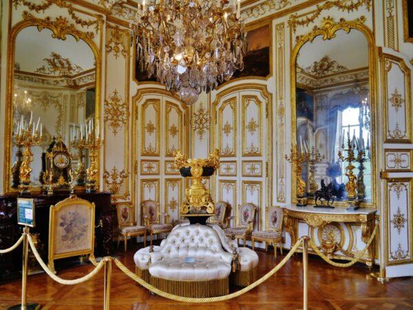 The large corner room was where the Princes of Condé held audiences. The seats and chairs are neoclassical, from the reign of Louis XVI. The fireplace screen belonged to the future King Louis XVII. The white and gold woodwork is also an example of the typical 18th-century French décor used at court in ceremonial rooms. The Duke of Aumale collected this furniture and decorative arts from the royal family as well as from the royal châteaux to recreate the opulence of his ancestors. (<a href="https://commons.wikimedia.org/wiki/File:Chantilly_Ch%C3%A2teau_de_Chantilly_Innen_Grand_Cabinet_de_Monsieur_Le_Prince_1.jpg">Zairon/CC BY-SA 4.0</a>)