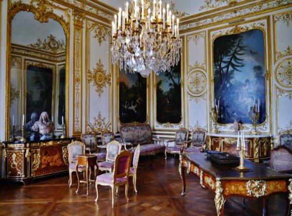 This public room in the large suites is typical of the early Rococo style with its white and gold panels and ornamentation. The paneling was designed by the architect Jean Aubert around 1720 for Louis-Henri de Bourbon, one of the princes of Condé and minister of King Louis XV. The chest of drawers by Jean-Henri Riesener was commissioned for the bedroom of King Louis XVI in Versailles. These were acquired by the Duke of Aumale for Chantilly. This room follows 18th-century fashion of the grandeur of the Condé princes. (<span style="color: #ff6600;"><a href="https://commons.wikimedia.org/wiki/File:Chantilly_Ch%C3%A2teau_de_Chantilly_Innen_Grand_Cabinet_de_Monsieur_Le_Prince_1.jpg">Zairon/CC BY-SA 4.0</a></span>)