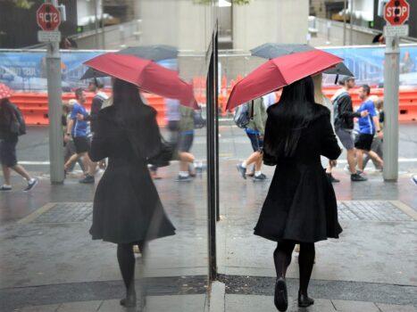 Pedestrians reflected on a marble wall in the central business district of Sydney, Australia, on April 4, 2017. (Saeed Khan/AFP via Getty Images)