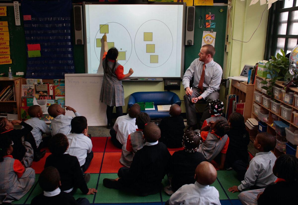 Teacher Shawn Abernathy (R) teaches math concepts using a modern computer projection board at Harlem Success Academy, a free, public elementary charter school in the Harlem neighborhood of New York City, on March 30, 2009. (Chris Hondros/Getty Images)