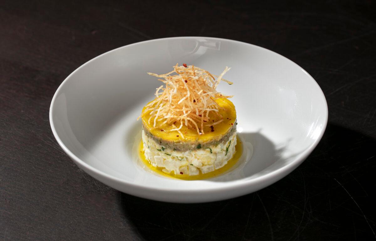 House-cured bacalhau, salt cod, is layered with cured egg yolk, crispy shredded potato, and tapenade. (Melissa Hom)
