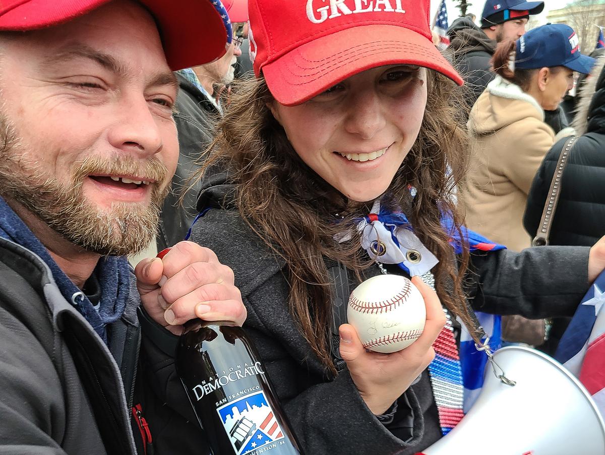 Megan Paradise and an unidentified man pose with items they said came from House Speaker Nancy Pelosi's office at the U.S. Capitol on Jan. 6, 2021. (Scott Wheeler/The Epoch Times)