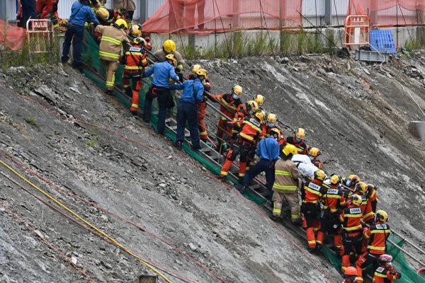 An injured person is carried from the scene by firefighters. (Sung Pi-Lung/The Epoch Times)
