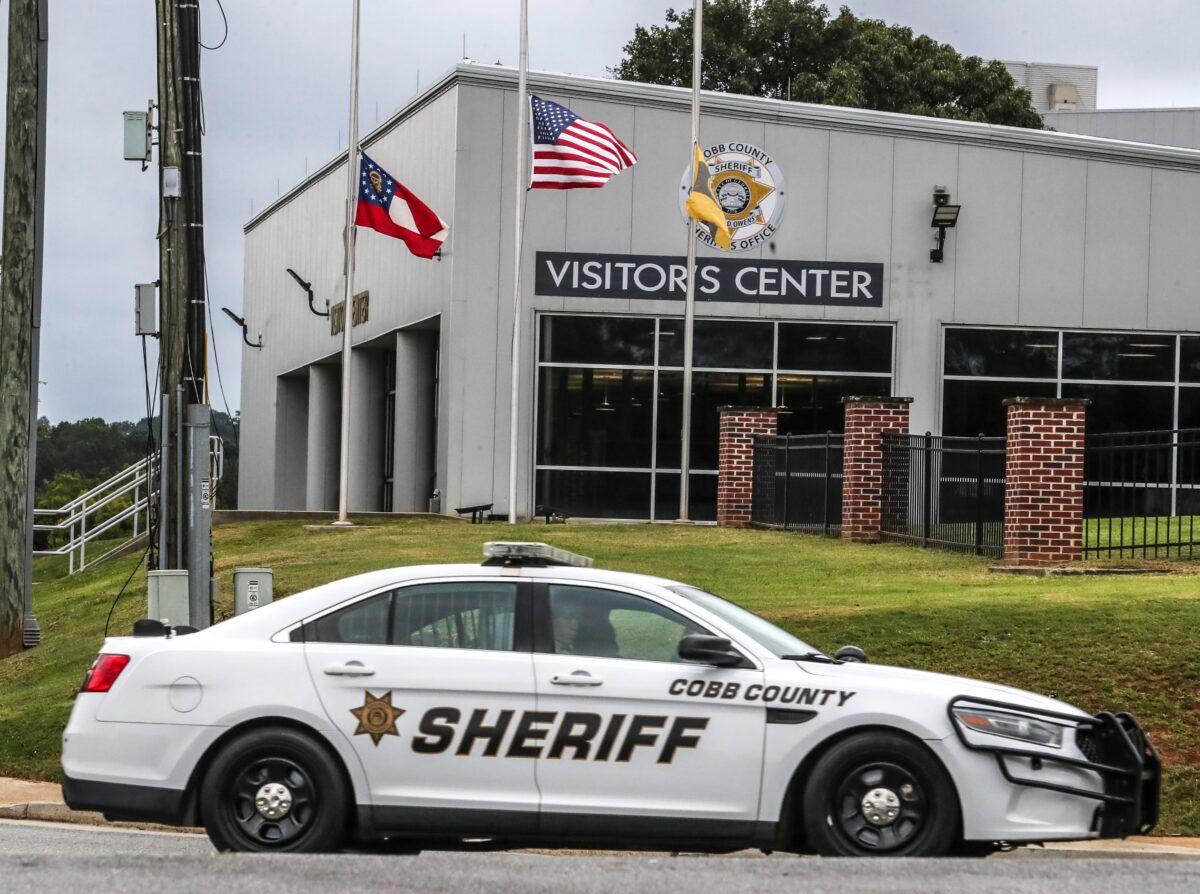 Flags were lowered to half staff at the Cobb County Sheriff's Office Adult Detention Center in Marietta, Ga., on Sept. 9, 2022. Two deputies were killed in an ambush while attempting to serve a warrant at a home in a suburb near Atlanta, a sheriff said Friday. (John Spink/Atlanta Journal-Constitution via AP)