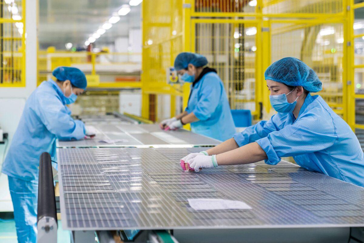 Workers are making solar photovoltaic modules used for small solar panels at a factory in Haian, in China's eastern Jiangsu Province, on Jan. 7, 2022. (STR/AFP via Getty Images)