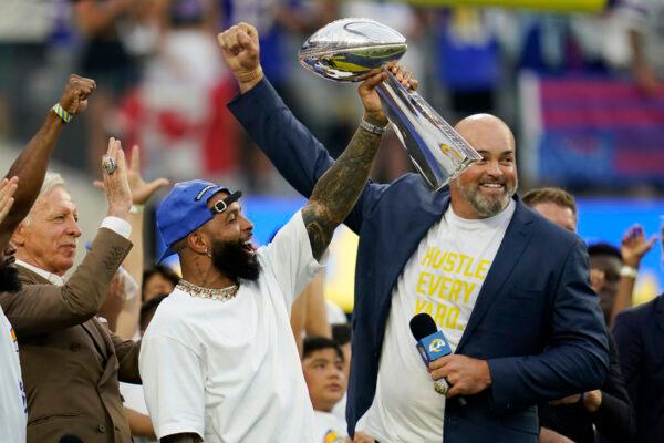 Former Los Angeles Rams wide receiver Odell Beckham Jr., center, lifts the 2021 championship trophy next to ex-player Andrew Whitworth, right, and team owner Stan Kroenke, left, before an NFL football game against the Buffalo Bills in Inglewood, Calif., on Sept. 8, 2022. (Ashley Landis/AP Photo)