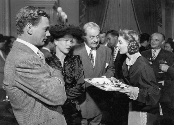 Loretta Young as Katrin Holstrom (R) serves guests in the home of Sen. Morley, played by Joseph Cotten (L), in "The Farmer's Daughter." (MoviestillsDB)