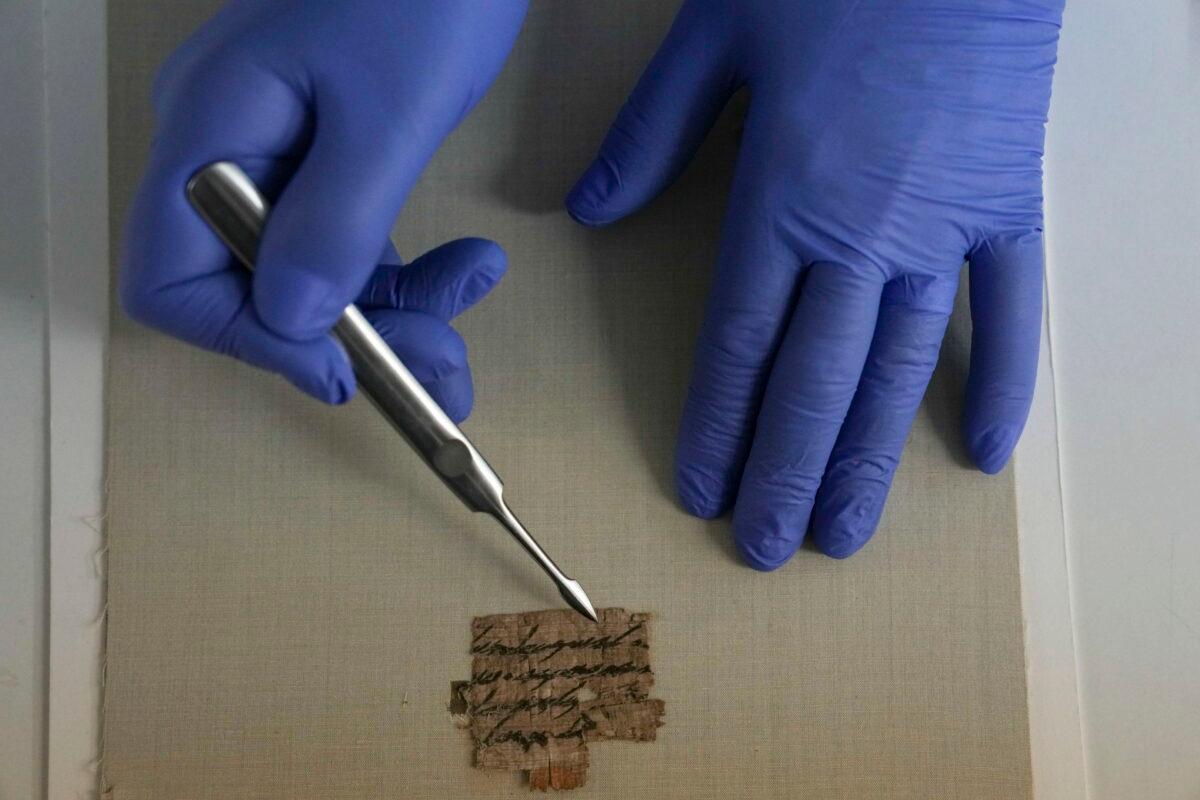 Israeli Antiquities Authority's official conservator, Tanya Bitler, shows a papyrus fragment at their lab inside the Israel Museum in Jerusalem on Sept. 7, 2022. (Ariel Schalit/AP Photo)