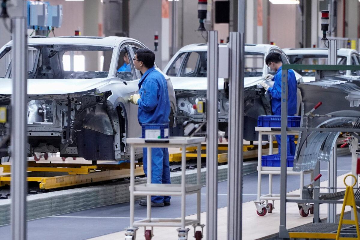 Employees work on the assembly line during a construction completion event at the SAIC Volkswagen MEB electric vehicle plant in Shanghai on Nov. 8, 2019. (Aly Song/Reuters)