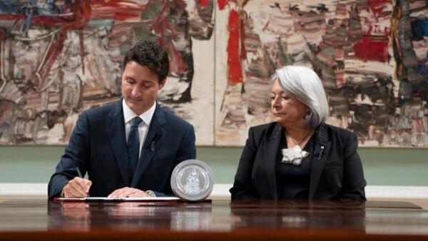 Governor General Mary Simon looks on as Prime Minister Justin Trudeau signs documents during an accession ceremony at Rideau Hall, in Ottawa, on Sept. 10, 2022. (The Canadian Press/Adrian Wyld)