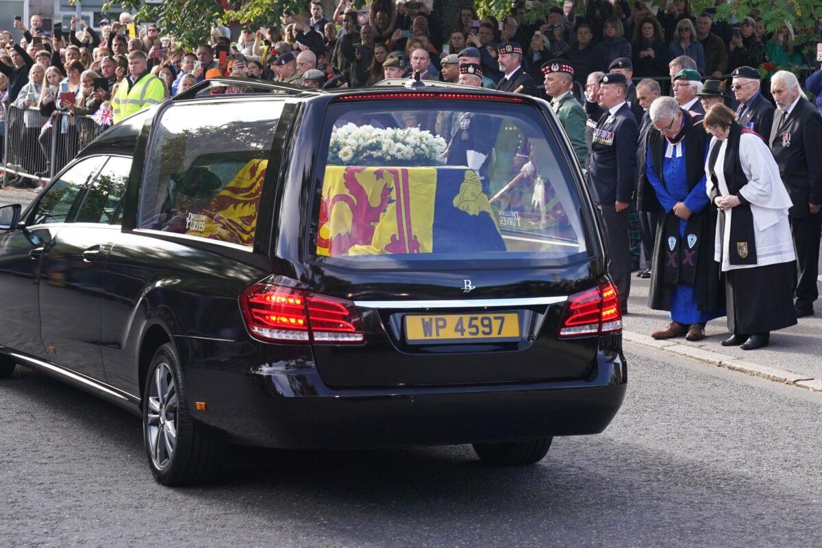 The hearse carrying the coffin of Queen Elizabeth II, draped with the Royal Standard of Scotland, passing through Ballater as it continues its journey to Edinburgh from Balmoral on Sept. 11, 2022. (Andrew Milligan/PA Media)