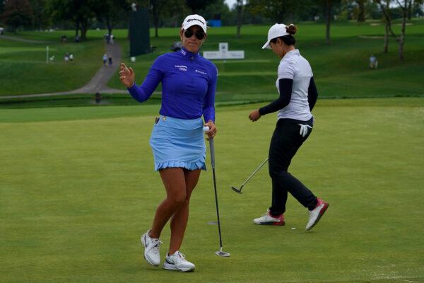 Maria Fassi of Mexico reacts after making birdie on the 11th green, as Xiyu Lin of China prepares to putt, during the final round of the Kroger Queen City Championship at Kenwood Country Club in Cincinnati, on Sept. 11, 2022. (Dylan Buell/Getty Images)