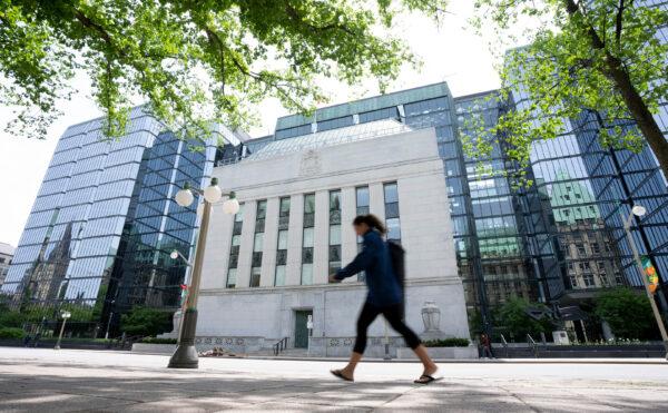 A woman walks past the Bank of Canada headquarters in Ottawa, on June 1, 2022. (THE CANADIAN PRESS/Adrian Wyld)