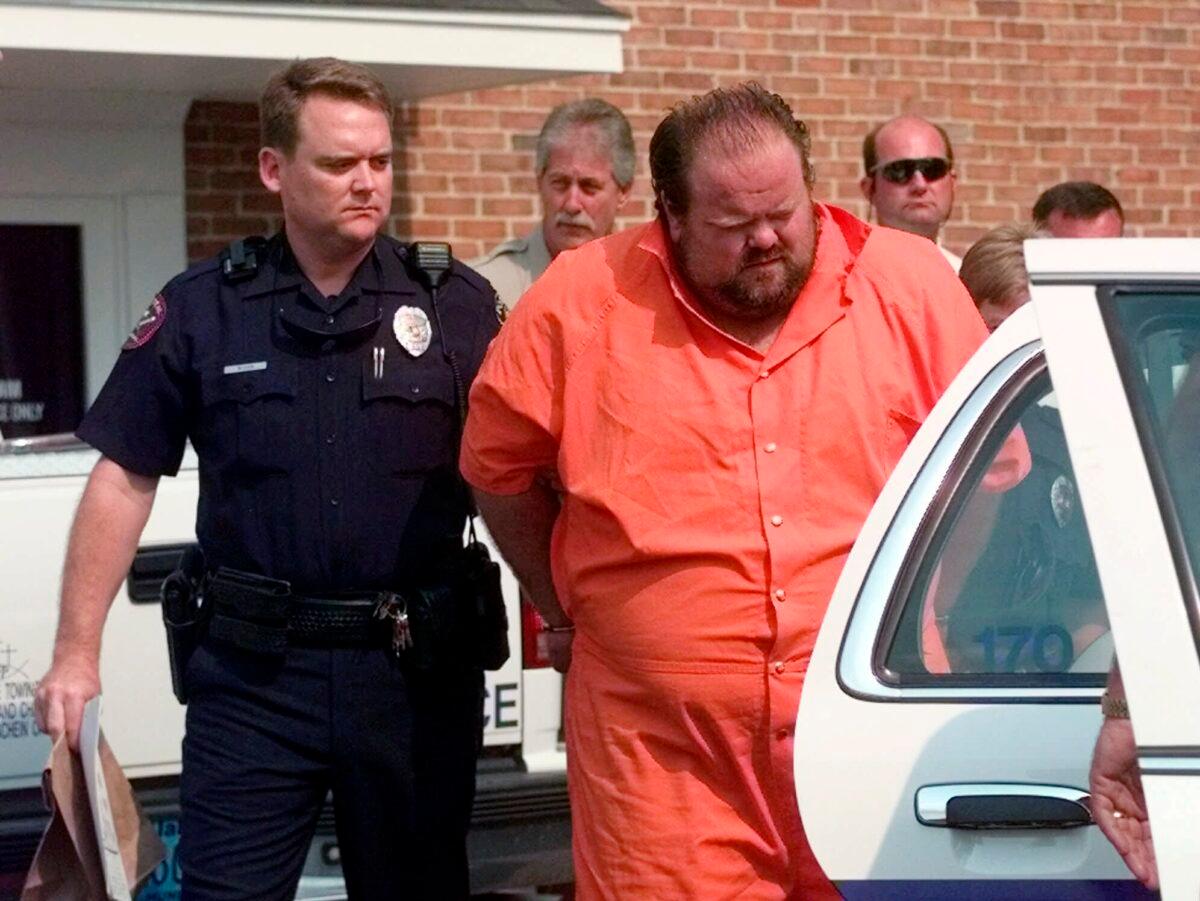 Officials escort murder suspect Alan Eugene Miller away from the Pelham City Jail in Alabama on Aug. 5, 1999. (Dave Martin/AP Photo)