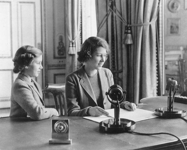  Princess Elizabeth makes her first broadcast, accompanied by her younger sister Princess Margaret Rose in London, on Oct. 12, 1940. (Getty Images)