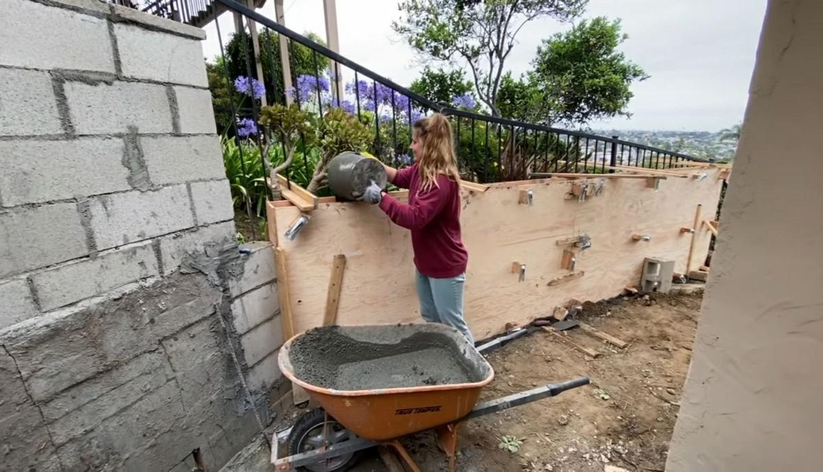 Taylor Raine Koutroumbis pouring concrete to build a new retaining wall. (Courtesy of <a href="https://www.instagram.com/mykidsaredirtyagain/">Taylor Raine</a>)