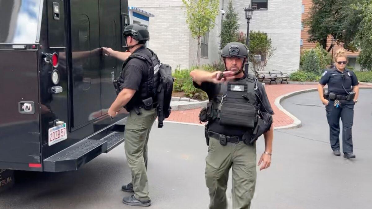 A Boston Police bomb squad officer motions for members of the media to step away from police vehicles on the campus of Northeastern University in Boston on Sept. 14, 2022, in a still from video. (Rodrique Ngowi/AP Photo)