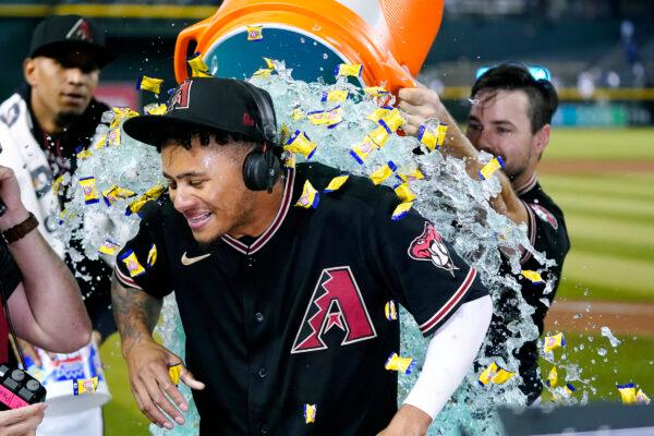 Arizona Diamondbacks' Sergio Alcantara gets showered with liquid and bubble gum by Cooper Hummel, right, after his game-ending, three-run home run in the 10th inning against the Los Angeles Dodgers in a baseball game in Phoenix, on Sept. 14, 2022. (Ross D. Franklin/AP Photo)